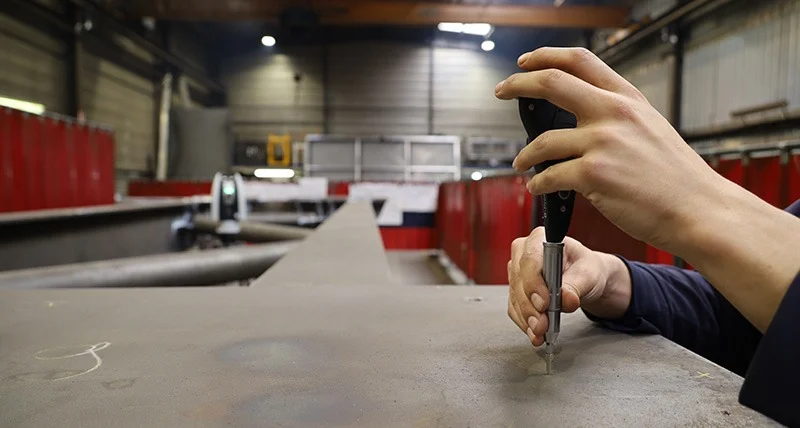 Leica B-Probe Plus Measurement Feedback Operator using the Leica B-Probe Plus handheld probe on a metal component in a workshop