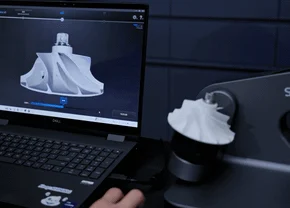 AutoScan Inspec2 Automatic 3D Scanning with 3-Axis Turntable AutoScan Inspec2 scanning a small component on its rotating platform beside a laptop displaying the captured 3D model.