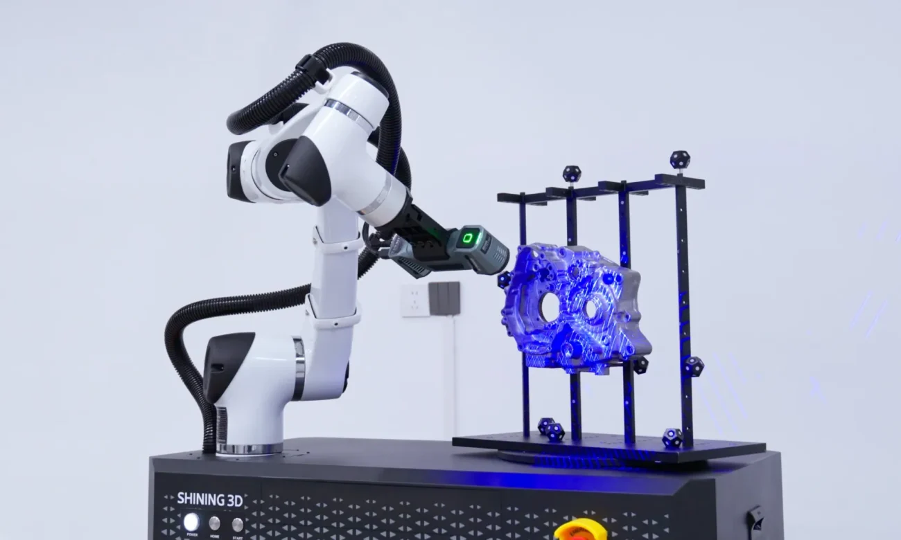 SHINING 3D RobotScan Combo+ Automated Industrial 3D Scanning RobotScan Combo+ hybrid light 3D scanner mounted on a robotic arm scanning a metal casting secured in an industrial inspection fixture.