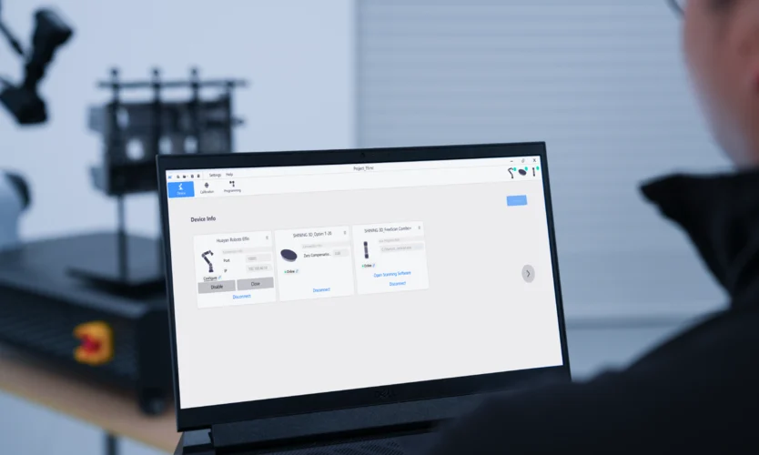 SHINING 3D RobotScan Control Software for Automated 3D Inspection RobotScan Control software interface displayed on a laptop with an automated robotic 3D scanning system in the background.