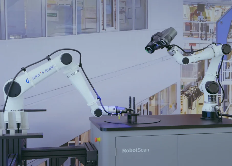 SHINING 3D RobotScan Automated Loading and Unloading System RobotScan automated 3D inspection system with two robotic arms for component loading, 3D scanning and unloading in an industrial production environment.