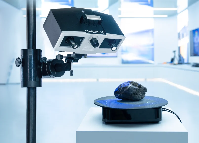 OptimScan 5M Plus Multiple Scanning Ranges SHINING 3D OptimScan 5M Plus optical 3D scanner mounted on an adjustable stand, scanning an object on a rotating turntable.